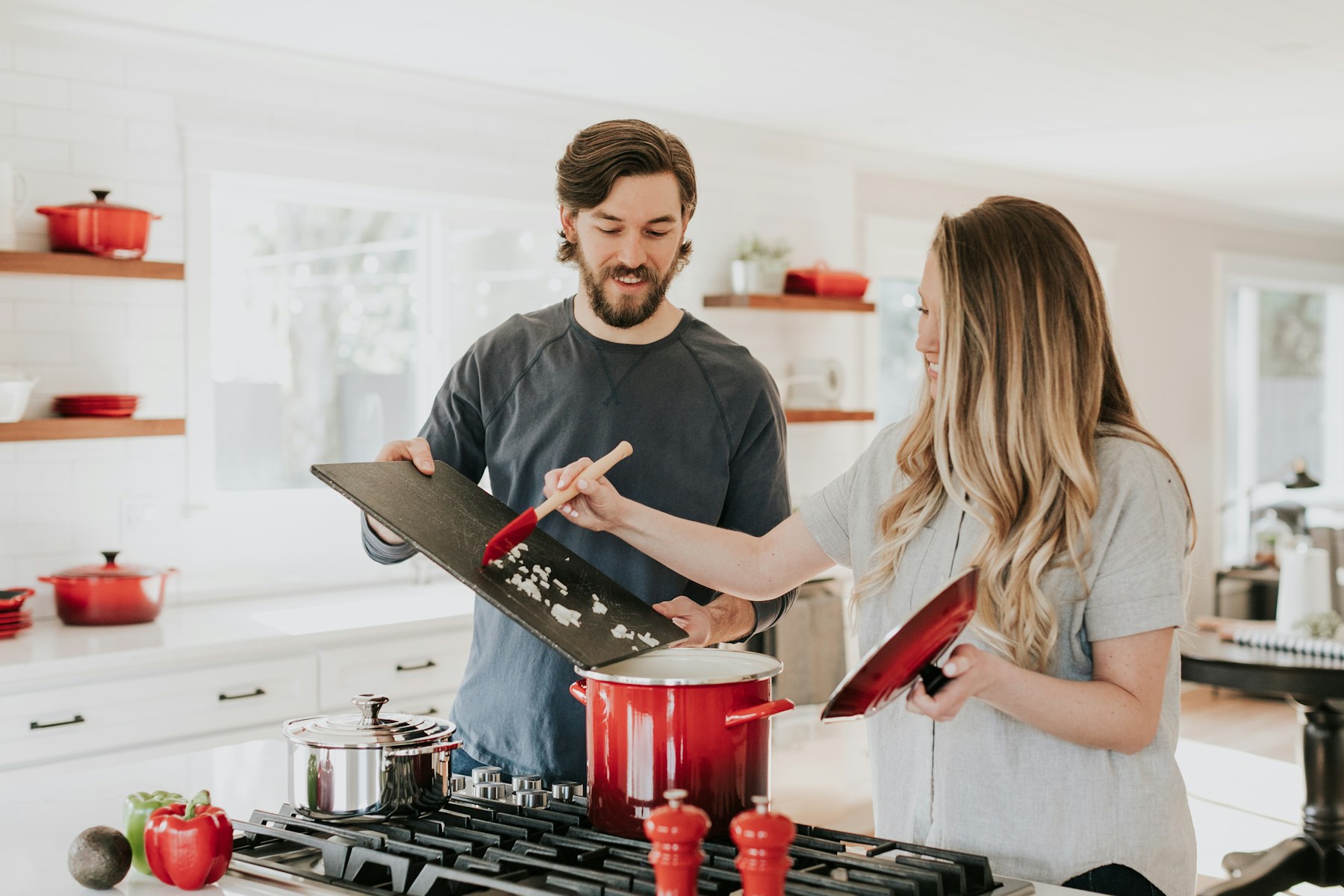 A couple cooking together in a bright modern kitchen